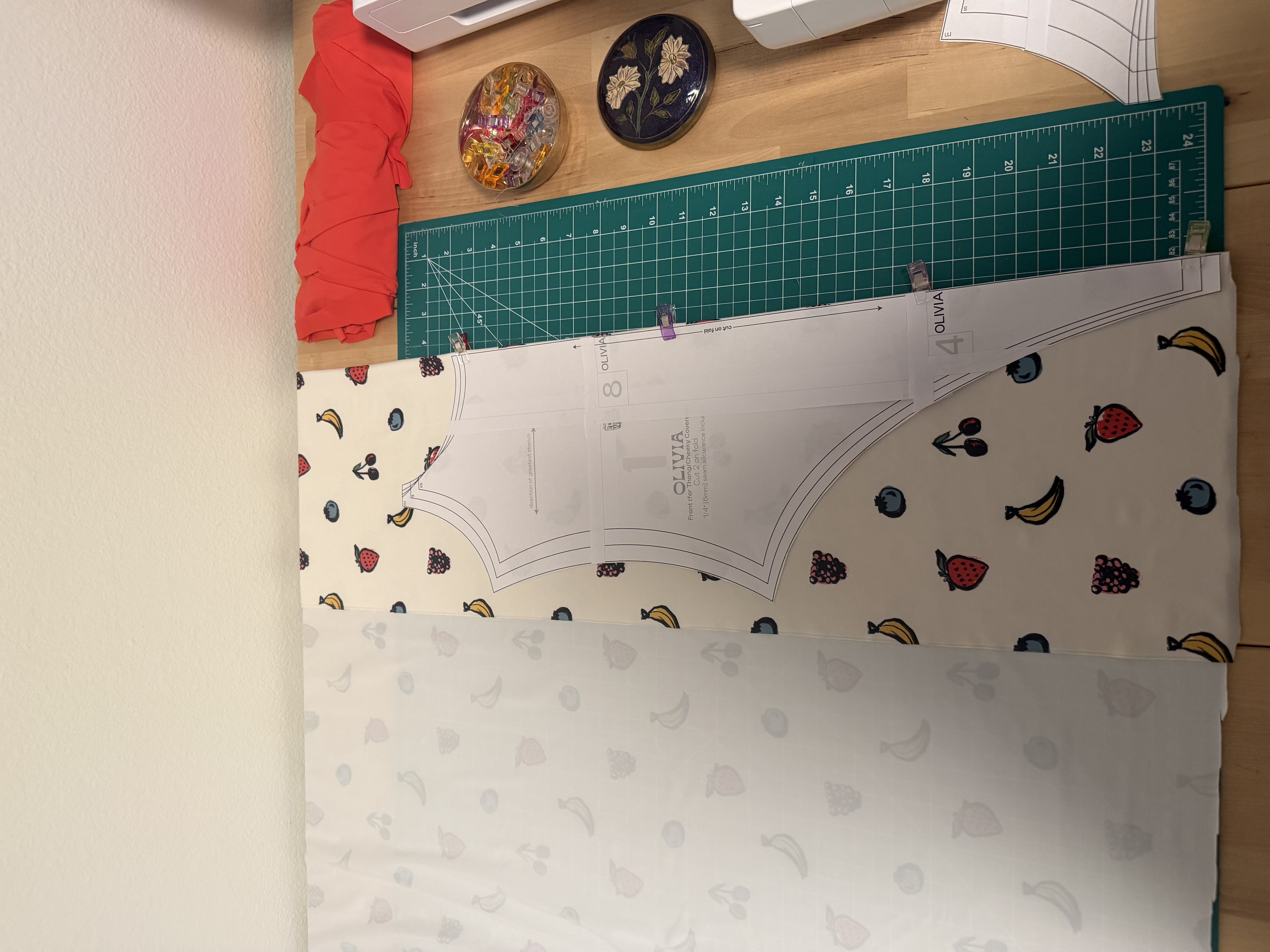 Olivia One Piece pattern pieces pinned to the fruit print fabric, ready to cut